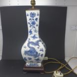 An early 20th century Chinese hand-painted blue and white lamp decorated with dragons on a fitted