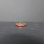 An 18ct yellow gold and caliber cut ruby ring