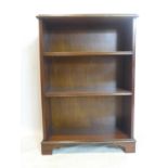 An early 20th century open bookcase, with brass carrying handles, on shaped bracket feet, H.89 W.