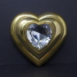 A vintage unused Yves Saint Laurent gilt metal heart-shaped powder compact adorned to the top with a