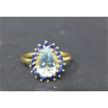 A 10ct yellow gold, aquamarine and sapphire ring, with central pear shaped aquamarine flanked by