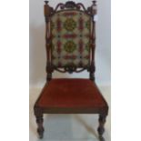 A Victorian mahogany nursing chair, with shell and scrolling crest rail, on turned supports and