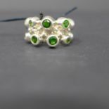 A sterling silver, chunky contemporary ring set with 7 round faceted green garnets, Size: O, 11.5g