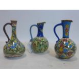 Three Persian Isfahan jugs, decorated with stylised flowers, H.25cm (largest)