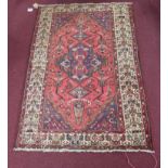 A North-West Persian Tafresh rug, diamond medallion with repeating petal motifs on a rouge field,