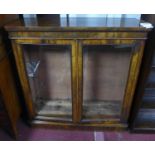 A Victorian walnut bookcase with 2 glazed doors, enclosing adjustable shelves, raised on stepped