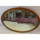 A late 19th century oval satinwood mirror with bevelled plate, 67 x 100cm