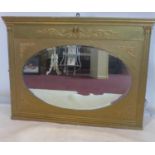 A late 19th/early 20th century gilt wood over mantle mirror, with oval bevelled plate, 74 x 97cm