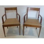 A pair of Regency style armchairs, with ebony inlay and leather seats