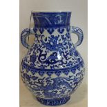 A Chinese blue and white twin handled vase, decorated with dragons and scrolling foliage, bearing
