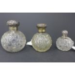 Three silver topped crystal jars, the silver tops with C-scroll and scrolling foliate decoration,