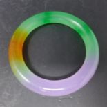 A Chinese green, purple and orange hard stone bangle, D.9cm