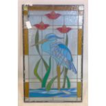 A stained glass panel depicting a crane within flowers, 92 x 56cm