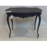 A Victorian ebonized center table with 2 side drawers, raised on cabriole legs and castors, H.74 W.