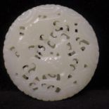A Chinese celadon jade circular pendant, carved and pierced decorated with bats and deer, 5cm
