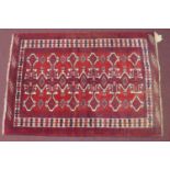 A north east Persian Yamut rug, with repeating stylized gull motifs, on a rouge field, within