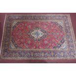 A Kashan carpet with Manchester wool, floral design on a red and blue ground, 296 x 205cm