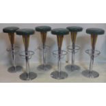 A set of six vintage heavy chrome bar stools with green leather seats