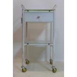 A 20th century white painted steel industrial trolley, with single drawer, raised on castors, H.96