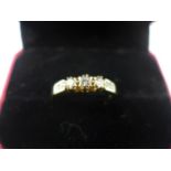 A 9ct gold ring set with 3 diamonds flanked by 4 small diamonds to shoulders, 2.4 grams