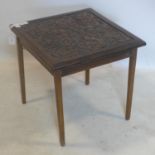 An early 20th century teak lamp table, with carved panel top, raised on tapered legs, H.51 W.55 D.