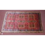 A north west Persian Kurdie carpet, the triple stylized eagle motifs on a terracotta field, within