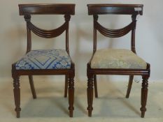 A pair of Regency mahogany chairs, with later floral upholstered drop-in seats, raised on reeded