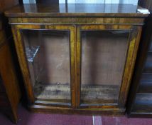 A Victorian walnut bookcase with 2 glazed doors, enclosing adjustable shelves, raised on stepped