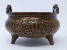 A Chinese bronze incense burner, with twist handles, raised on tripod feet, bearing six character