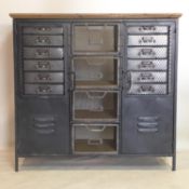 A Industrial style cabinet, with an arrangement of drawers and cupboard doors, raised on square