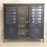 A Industrial style cabinet, with an arrangement of drawers and cupboard doors, raised on square