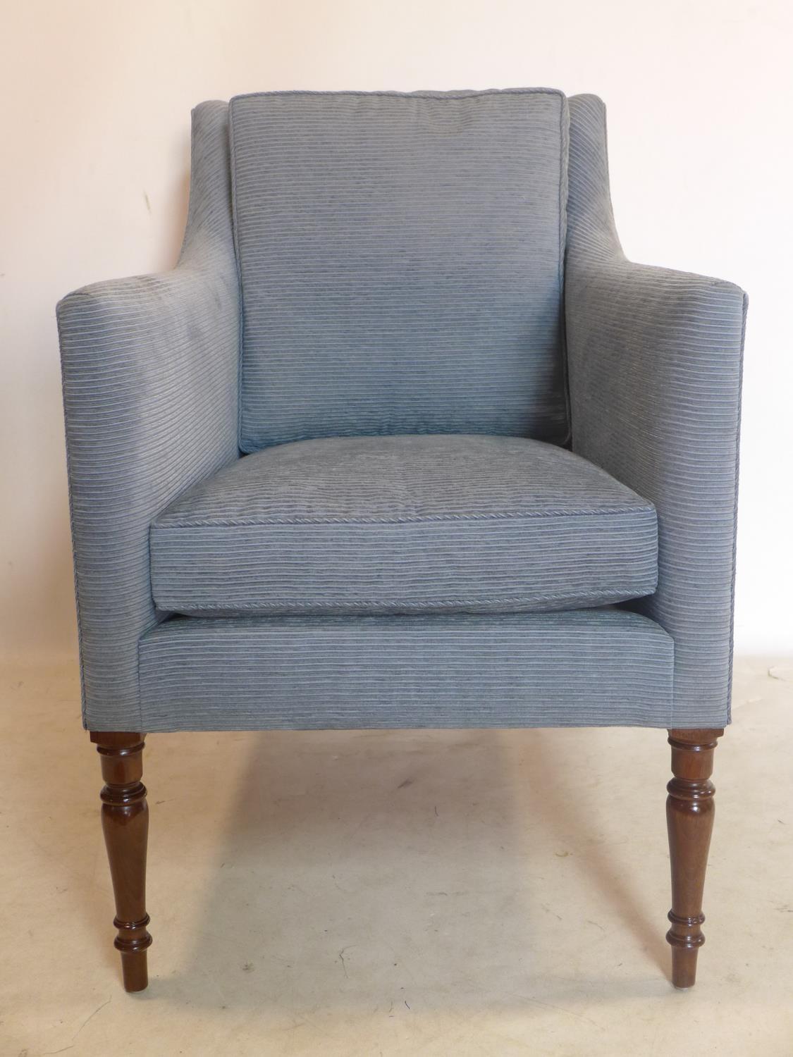 A Regency style armchair with blue corduroy upholstery, raised on turned legs