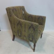 A paisley upholstered armchair raised on turned mahogany legs