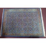 A mid 20th century part silk Tabriz rug, with repeating geometric floral motifs, on a blue ground,
