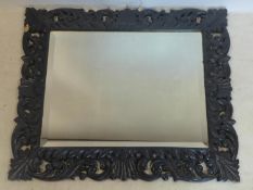 An early 20th century thick carved oak mirror with beveled plate, 86 x 100cm