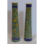 Two Persian Isfahan bamboo vases, decorated with stylised flowers, one with firing crack to base,