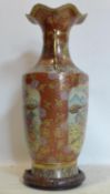 A Japanese Satsuma style vase, decorated with vignettes of figures, flowers and birds on an orange/