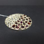 A sterling silver, contemporary, large circular pendant set with 22 polished natural garnets and