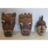 Two South East Asian carved and painted wooden dragon masks, H.42cm; H.37cm; together with an