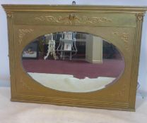 A late 19th/early 20th century gilt wood over mantle mirror, with oval bevelled plate, 74 x 97cm