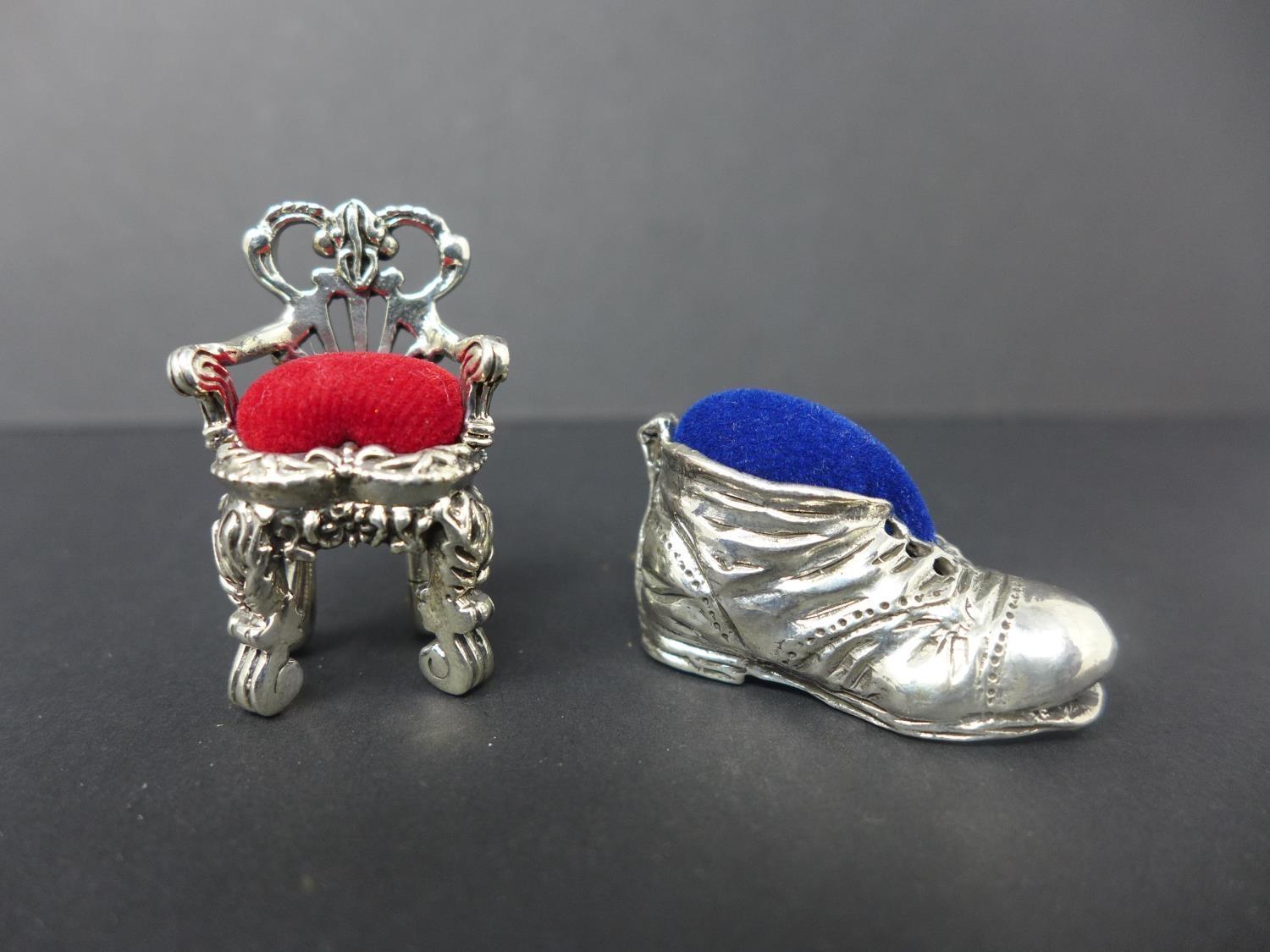 Two white metal pin cushions, one in the form of a shoe, H.1.7 W.3 D.1.7cm, and one in the form of