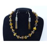 A Tiger's eye beaded necklace, a tiger's eye pendant and a pair of tiger's eye earrings, each with