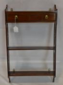 A 20th century mahogany wall hanging shelves with single drawer