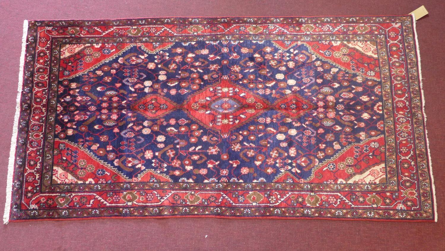 A North-West Persian Nahawand rug, central double pendent medallion with repeating petal motifs on a