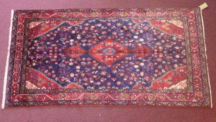 A North-West Persian Nahawand rug, central double pendent medallion with repeating petal motifs on a