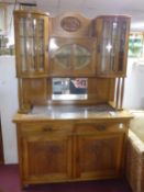 An Arts & Crafts walnut cabinet with 3 bevel glass cupboard doors above bevelled mirror and marble