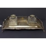 A 19th century silver desk stand, with pen rest and two cut glass inkwells, having pierced sides,