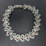 A white metal and emerald set bracelet