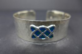 A Celtic style white metal and enamel bangle