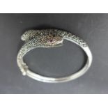 A white metal and marcasite snake bangle with ruby eyes